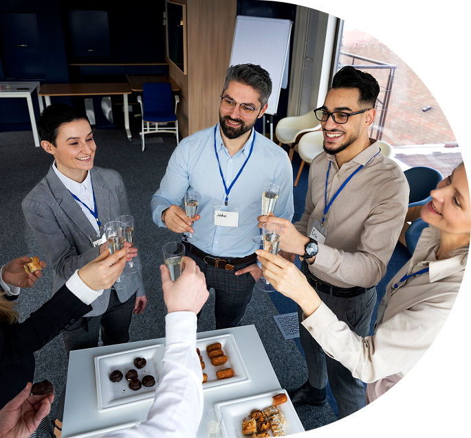 Grupo de profesionales brindando con copas en un ambiente de networking empresarial, mostrando conexión y celebración entre miembros del club Aserenet